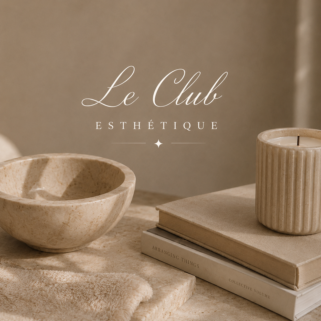 Le Club Esthétique script logo over a stone bowl, books and a candle in warm beige tones
